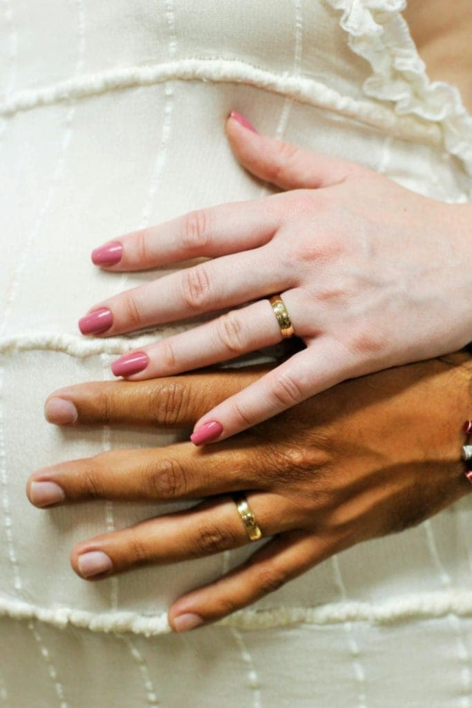 Jeweller showing curved, straight and contoured wedding bands on a velvet tray