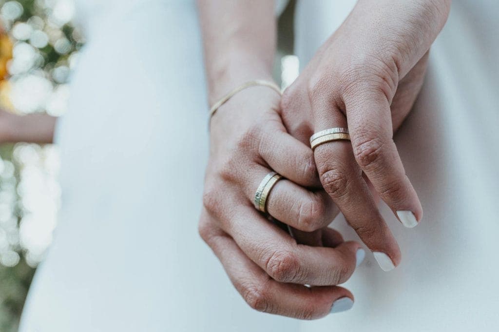 Hands using a ring sizer beside sketches and notes at a jewellery desk