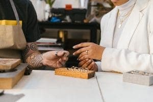 Shopper and jeweller discussing engagement ring options over a counter